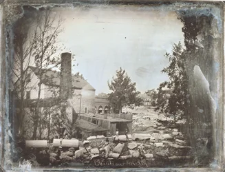 Uomini seduti su rocce e quelli che sembrano essere colonne architettoniche